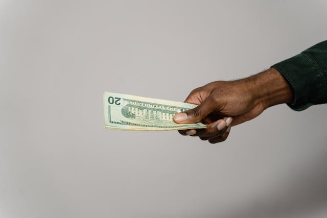 person passing a stack of money
